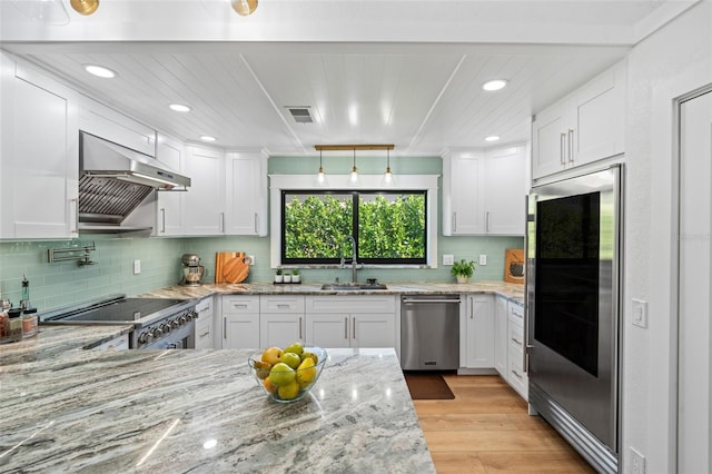 kitchen featuring appliances with stainless steel finishes, white cabinets, and a sink