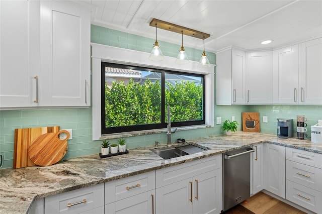 kitchen featuring decorative light fixtures, decorative backsplash, white cabinetry, a sink, and dishwasher