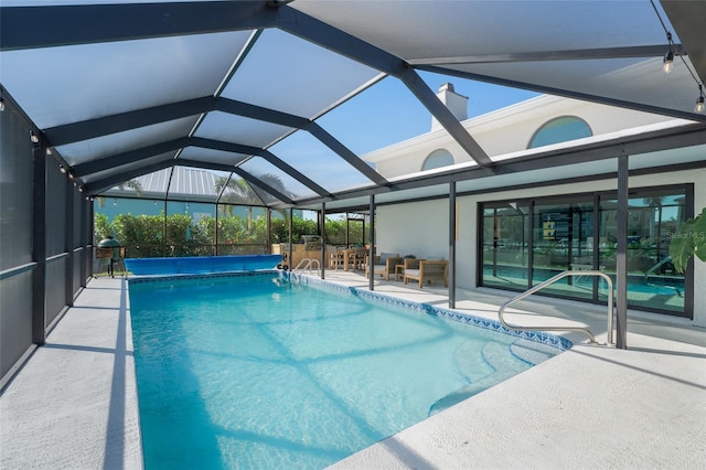 view of swimming pool featuring a bar, glass enclosure, a covered pool, and a patio area