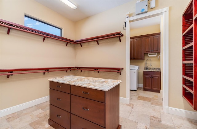 spacious closet with washer / clothes dryer and sink