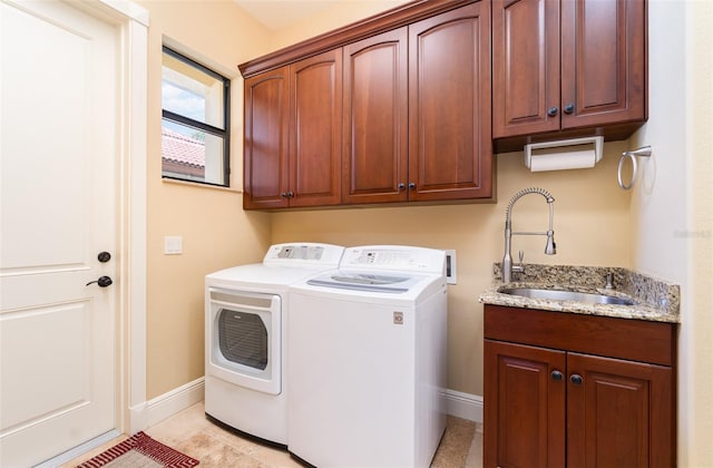 laundry area featuring cabinets, washer and clothes dryer, and sink