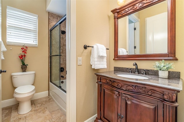 full bathroom with enclosed tub / shower combo, vanity, and toilet