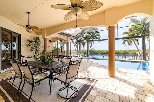 exterior space featuring ceiling fan, glass enclosure, and a water view