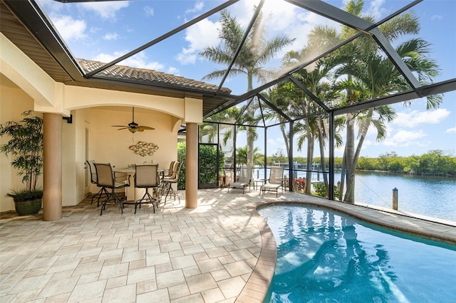 view of swimming pool featuring a water view, ceiling fan, a lanai, and a patio area