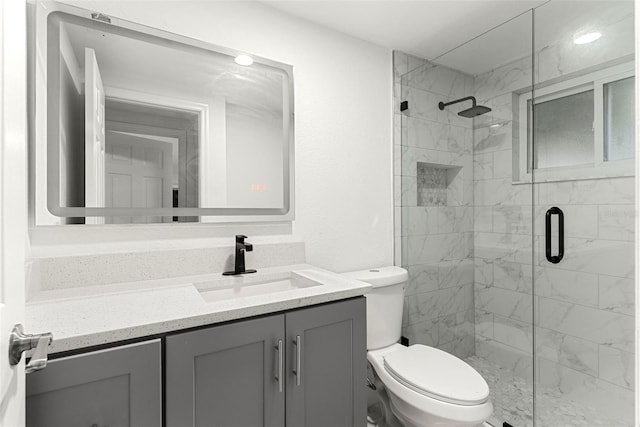 bathroom with vanity, walk in shower, and toilet