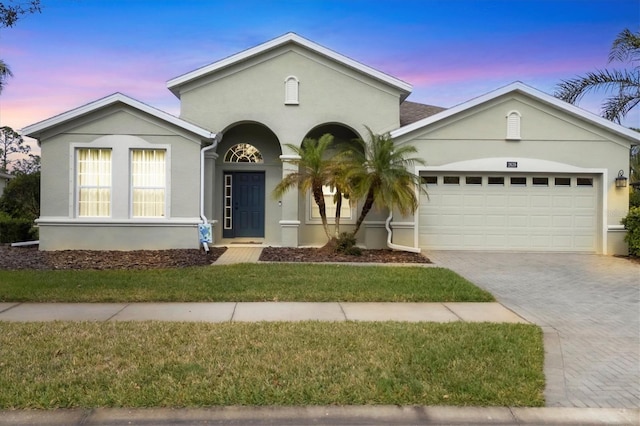 view of front of house with a garage and a lawn