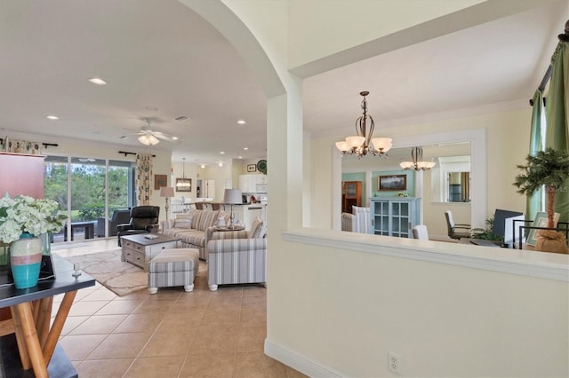 tiled living room featuring ceiling fan with notable chandelier