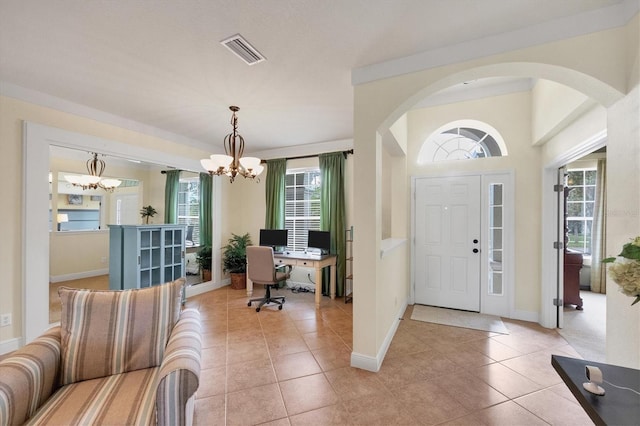 entryway featuring light tile patterned floors and a chandelier