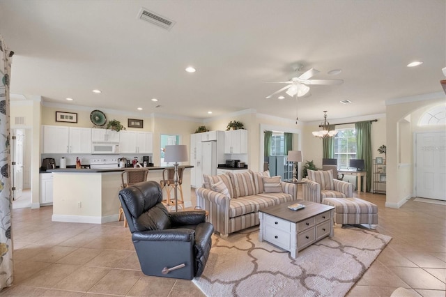 living room featuring light tile patterned floors, ceiling fan with notable chandelier, and ornamental molding