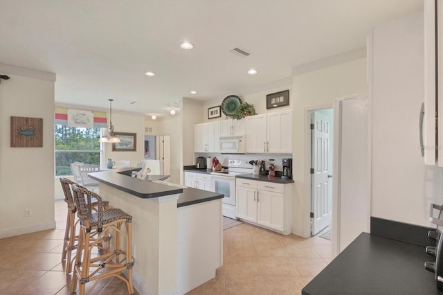 kitchen featuring hanging light fixtures, a kitchen island with sink, white cabinets, and white appliances