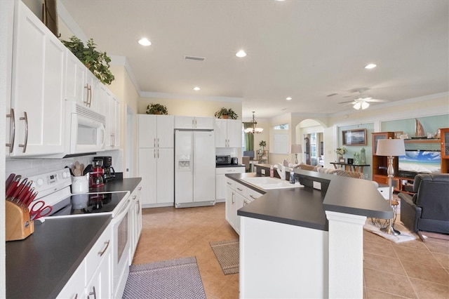 kitchen featuring sink, white cabinetry, light tile patterned floors, white appliances, and a kitchen island with sink