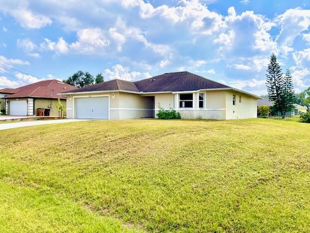 ranch-style home with a garage and a front lawn