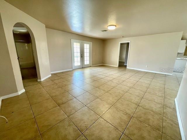 tiled empty room with french doors