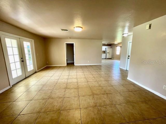 tiled empty room with french doors