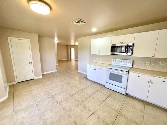 kitchen featuring white cabinetry, light tile patterned floors, and white range with electric cooktop