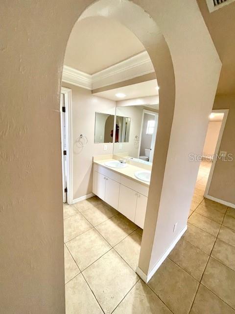 bathroom with vanity, tile patterned floors, and crown molding