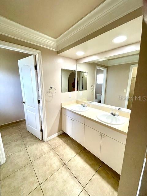 bathroom featuring crown molding, vanity, and tile patterned flooring