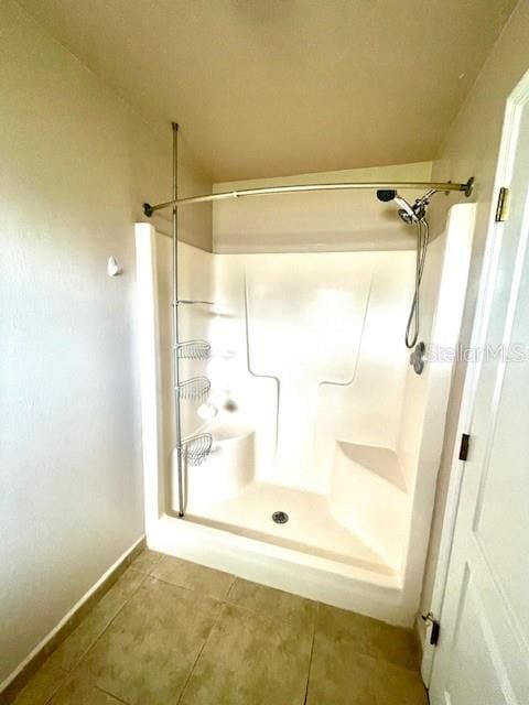 bathroom with tile patterned floors and a shower