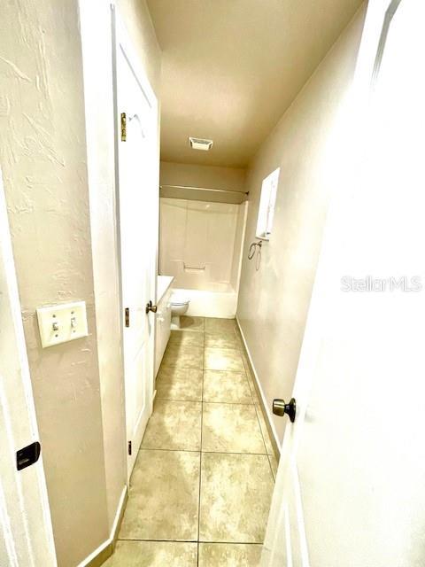 corridor with light tile patterned flooring