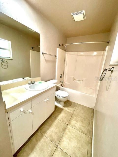 full bathroom with vanity, tile patterned floors, toilet, and washtub / shower combination