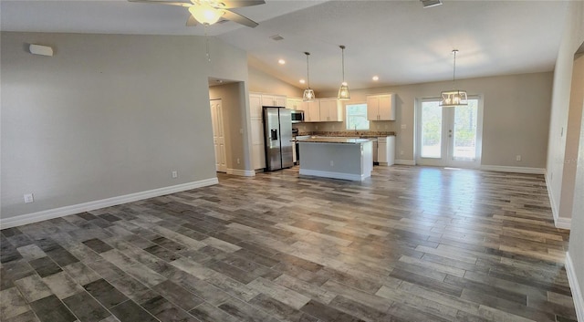 kitchen with open floor plan, a center island, hanging light fixtures, stainless steel appliances, and white cabinetry