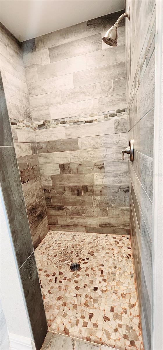 full bath featuring tiled shower