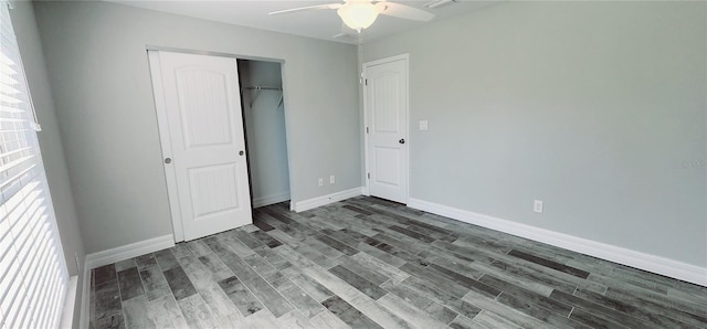 unfurnished bedroom featuring dark wood-style floors, a closet, ceiling fan, and baseboards