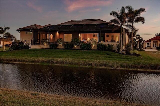 17122 Barcrest Ln, Punta Gorda, FL 33955 - view of front of property with a water view, stucco siding, a yard, and glass enclosure