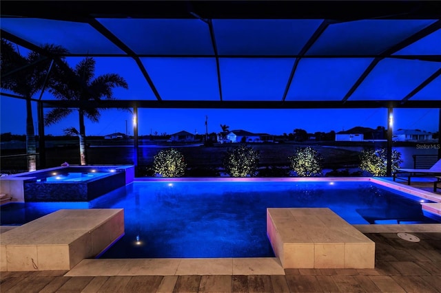 17122 Barcrest Ln, Punta Gorda, FL 33955 - pool at night with glass enclosure and a pool with connected hot tub