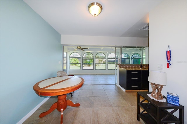 living area featuring ceiling fan, sink, and light tile patterned floors