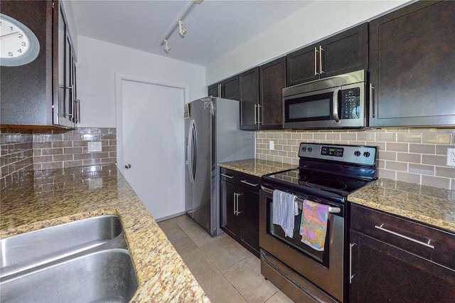 kitchen with stainless steel appliances, dark brown cabinets, and light stone counters