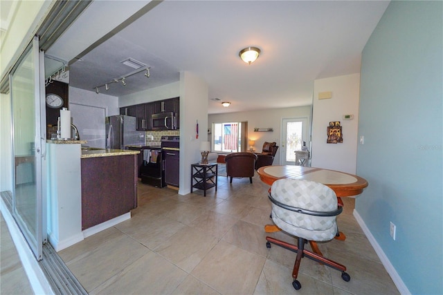 tiled dining area featuring sink and rail lighting