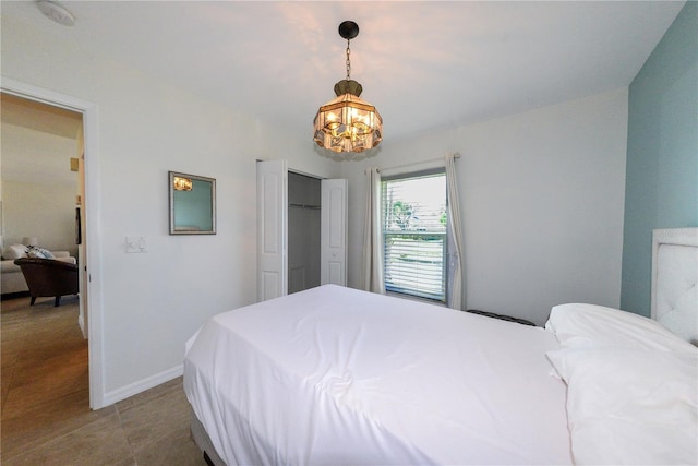 bedroom featuring tile patterned flooring, a closet, and a chandelier