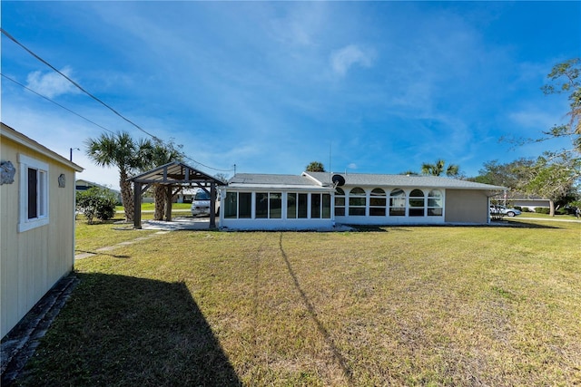 rear view of house featuring a yard, a gazebo, and a sunroom