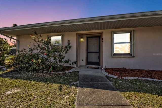 exterior entry at dusk with a lawn