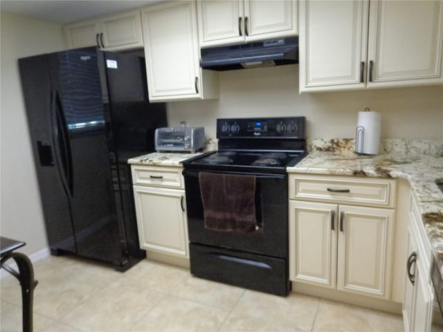 kitchen with light stone countertops, light tile patterned floors, and black appliances