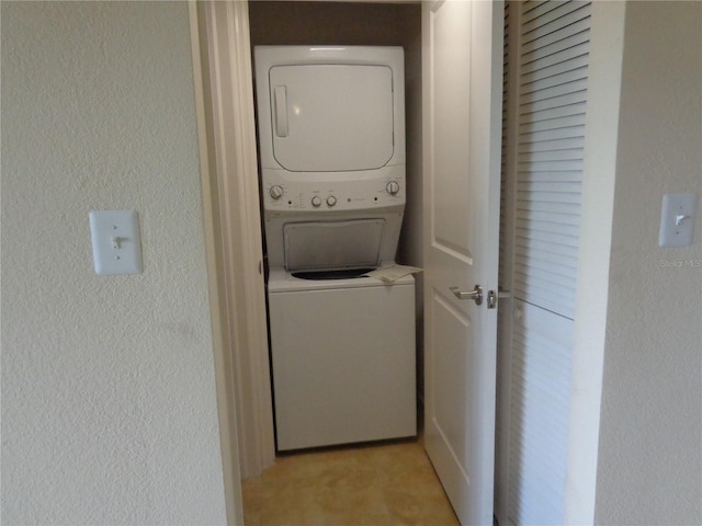 clothes washing area with stacked washing maching and dryer