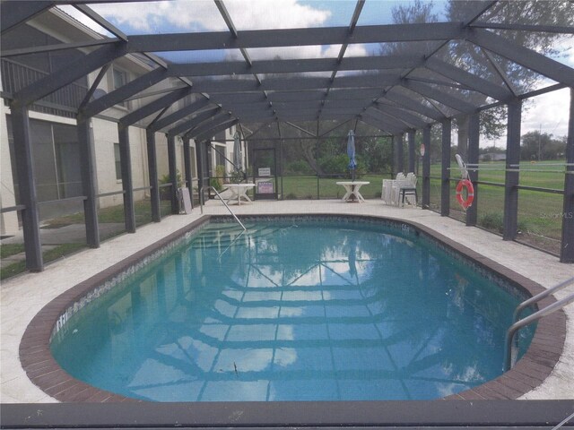 view of pool featuring glass enclosure and a patio area