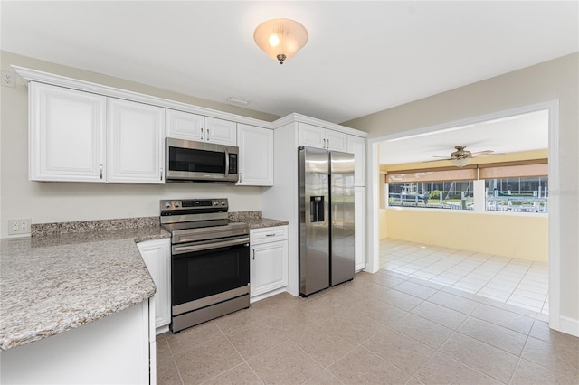 kitchen featuring light tile patterned floors, appliances with stainless steel finishes, ceiling fan, light stone countertops, and white cabinets