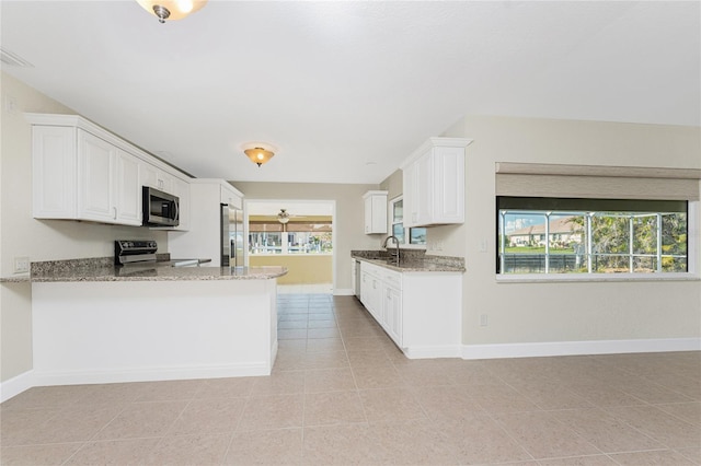 kitchen featuring white cabinetry, light stone counters, kitchen peninsula, and appliances with stainless steel finishes