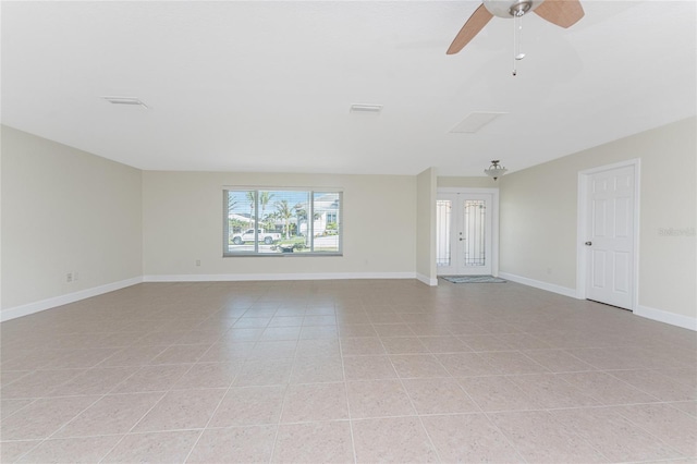 tiled spare room featuring french doors and ceiling fan