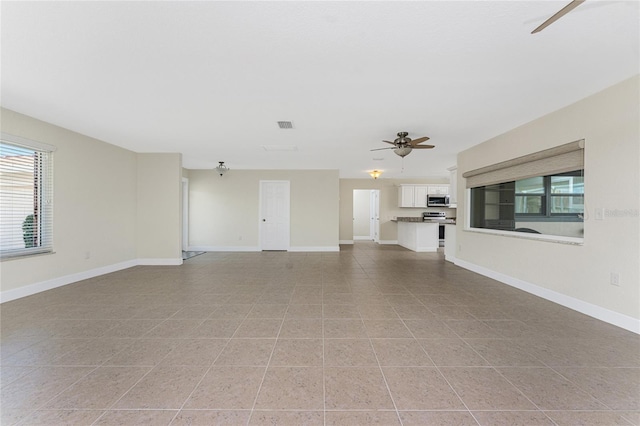 unfurnished living room featuring light tile patterned floors and ceiling fan