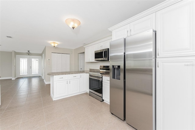 kitchen with white cabinetry, french doors, kitchen peninsula, and appliances with stainless steel finishes