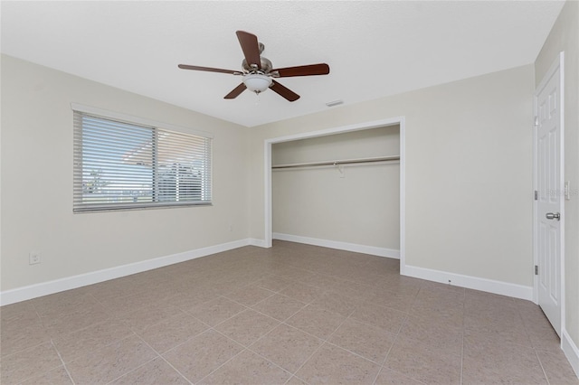 unfurnished bedroom featuring light tile patterned flooring, ceiling fan, and a closet