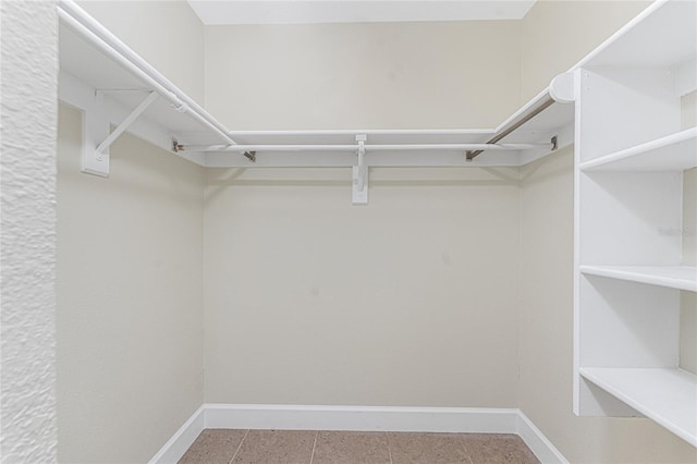 walk in closet with light tile patterned floors