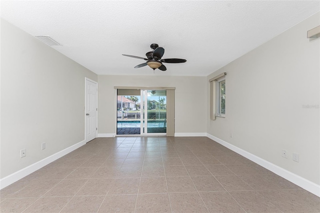 tiled empty room featuring a textured ceiling and ceiling fan