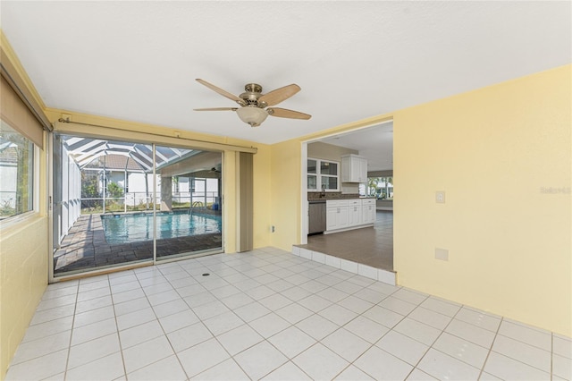 tiled empty room with plenty of natural light and ceiling fan