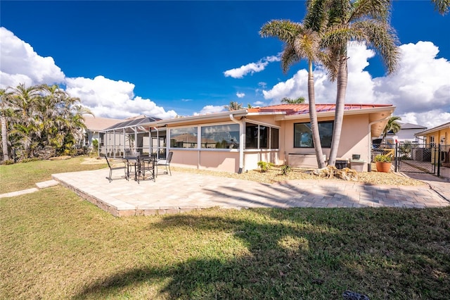 rear view of house with a yard, a patio area, and a lanai