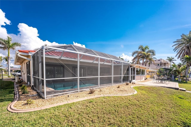 back of property with a lanai, a yard, and a patio area