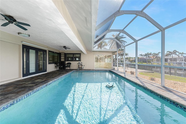 view of swimming pool with a patio, a lanai, and ceiling fan